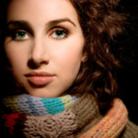 Woman with dark brown curly hair in winter scarf